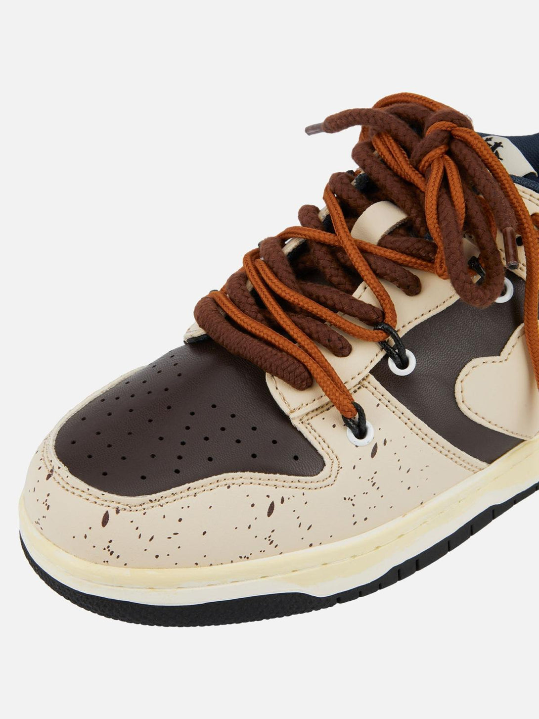 Zoomed-in view of TALISHKO sneakers in cream and brown with unique speckled design and bold laces.