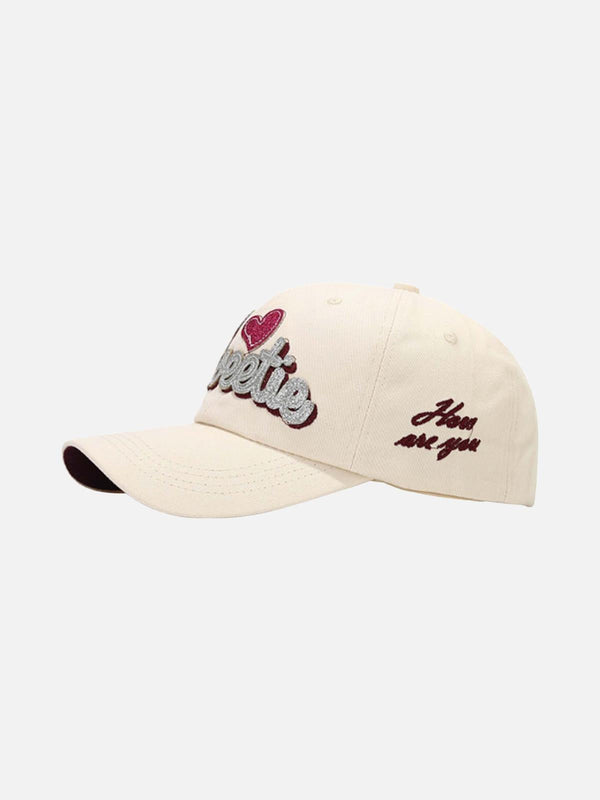 Cream baseball cap with embroidered text and heart detailing by TALISHKO, showcasing a stylish side view.