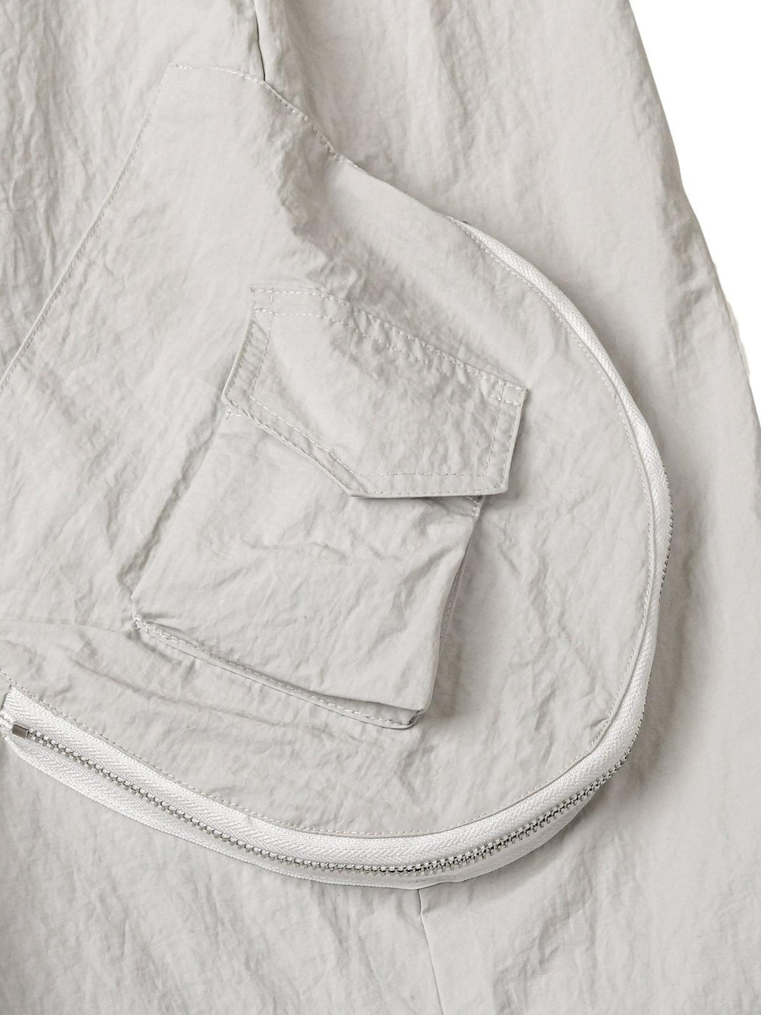 A detailed look at TALISHKO cargo pants' pocket design and zipper, emphasizing practicality.