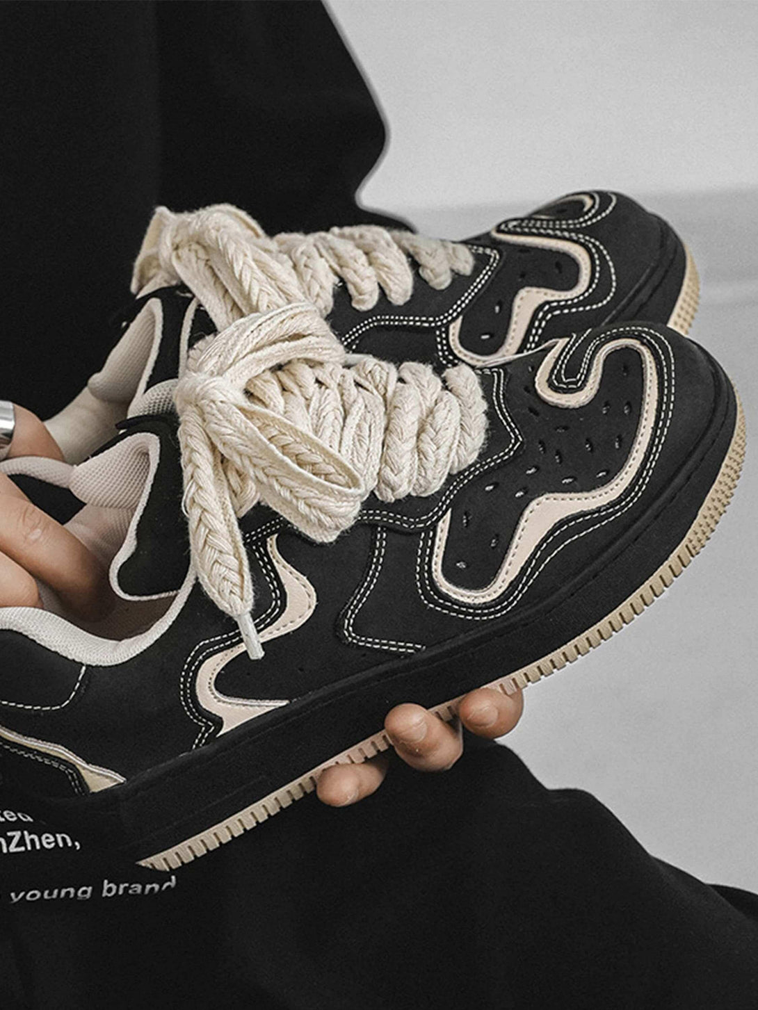 Bold black skateboard shoes by TALISHKO, featuring chunky cream laces and stylish stitching.