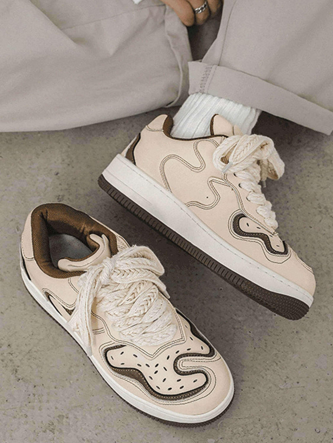 TALISHKO skateboard shoes in beige with unique patterns and thick laces, styled for casual wear.