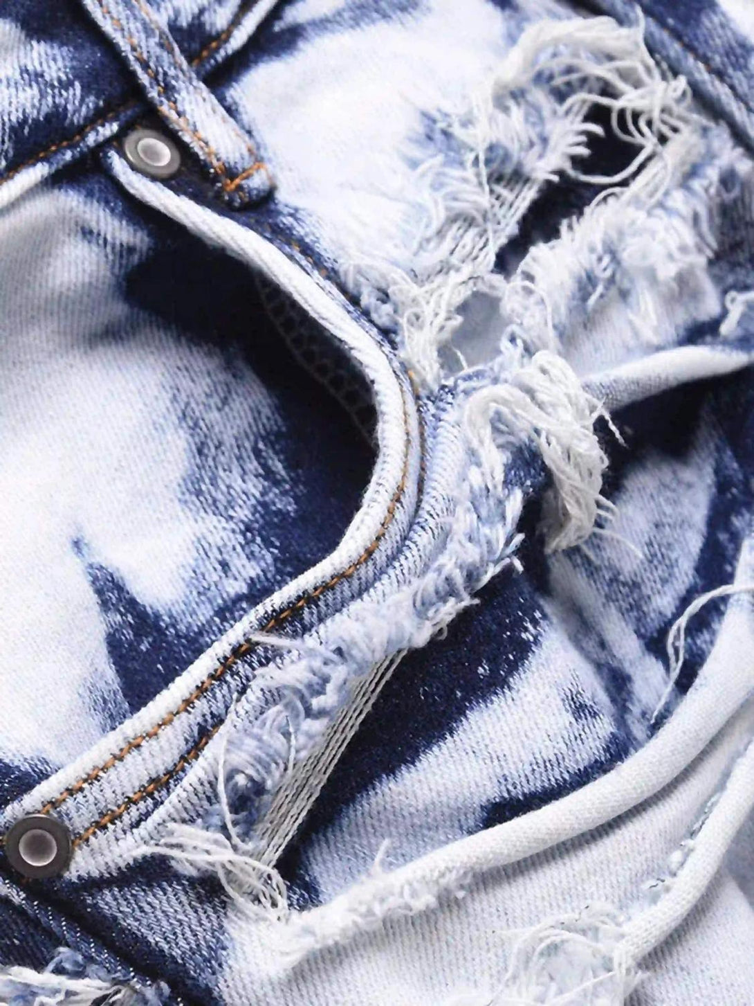 A tight crop highlighting TALISHKO's distressed denim, showcasing rugged texture and detail.