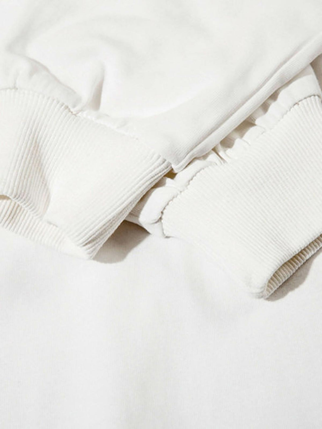 Intricate look at the white long sleeve polo cuff detail by TALISHKO, showcasing quality stitching.