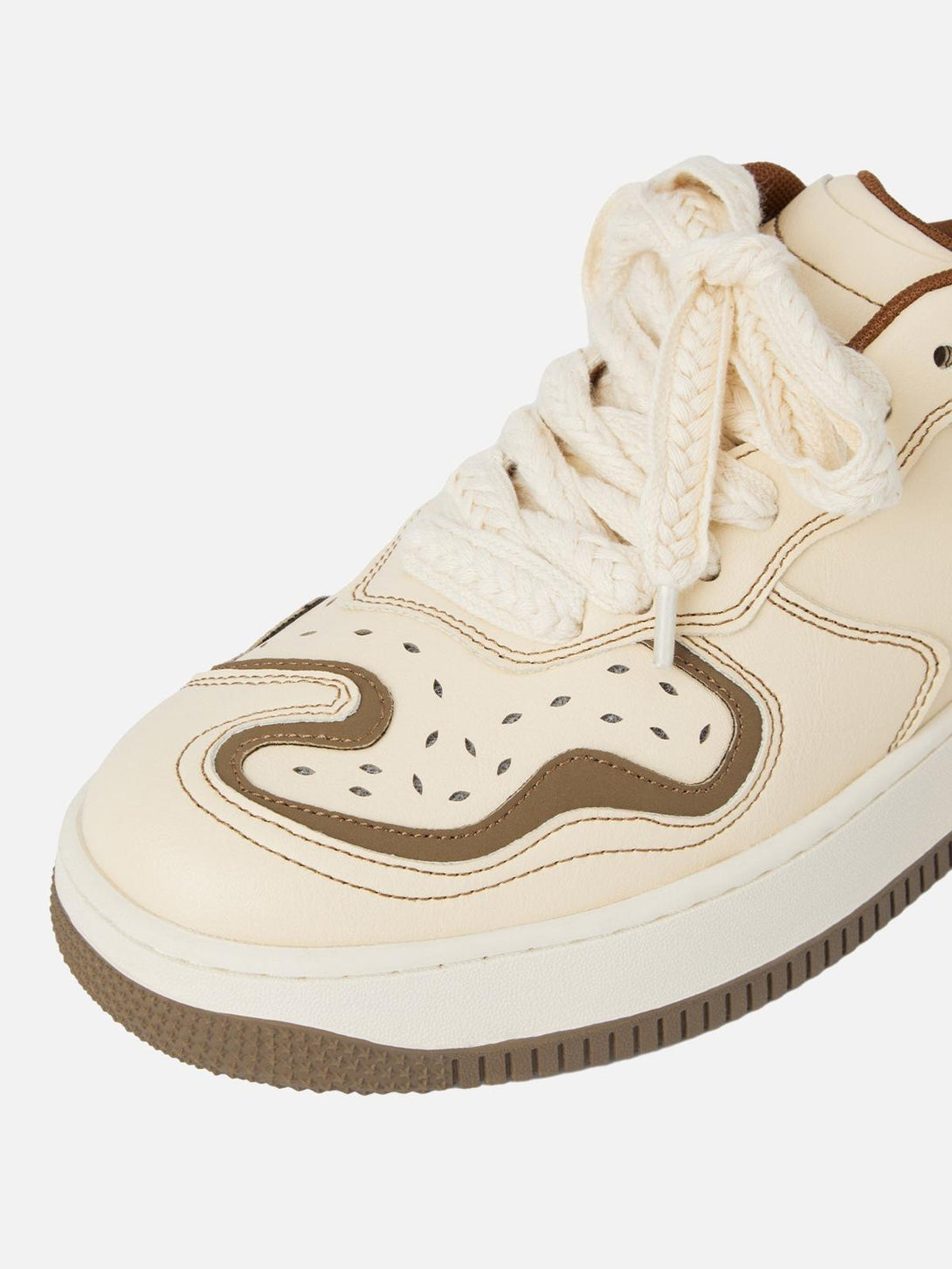 A close-up of TALISHKO skateboard shoes in beige, featuring unique brown accents and laces.