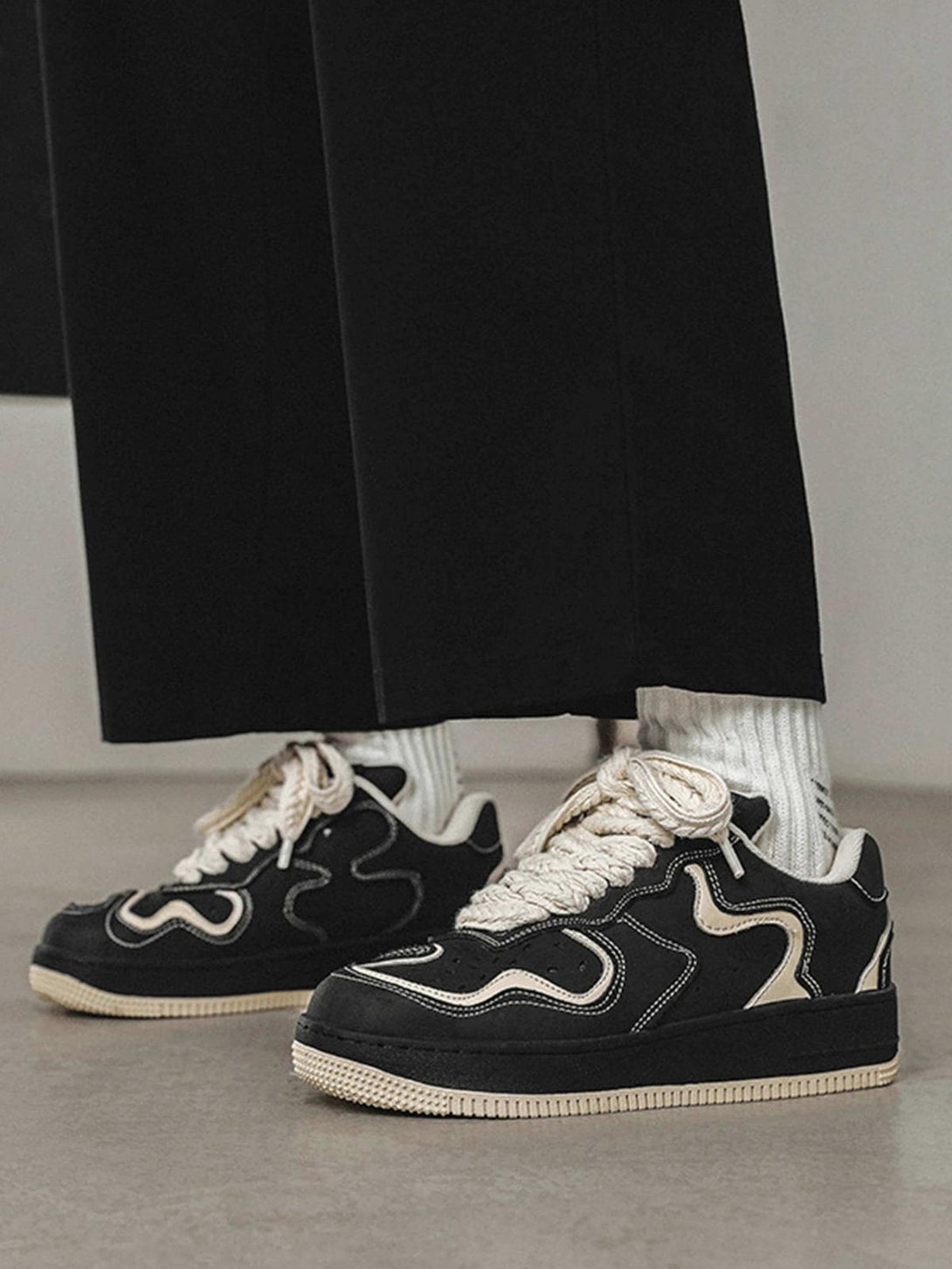 Model wearing TALISHKO skateboard shoes with bold cream accents and unique design elements.