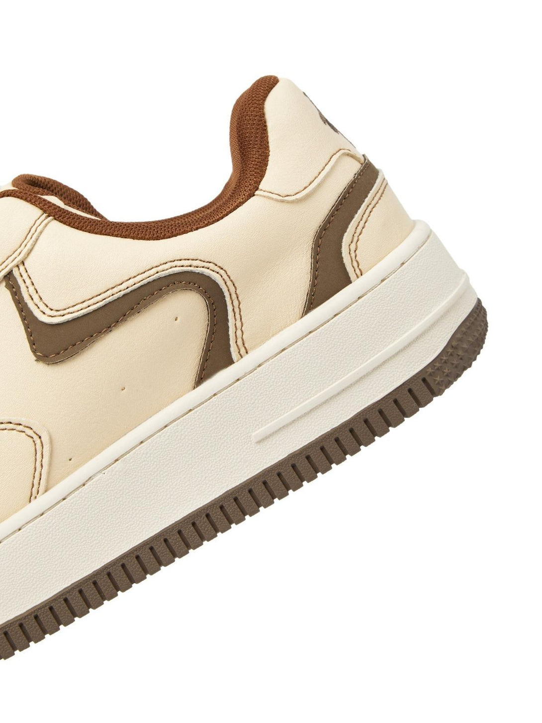 A detailed view of TALISHKO skate shoes in beige, showcasing brown accents and textured sole.