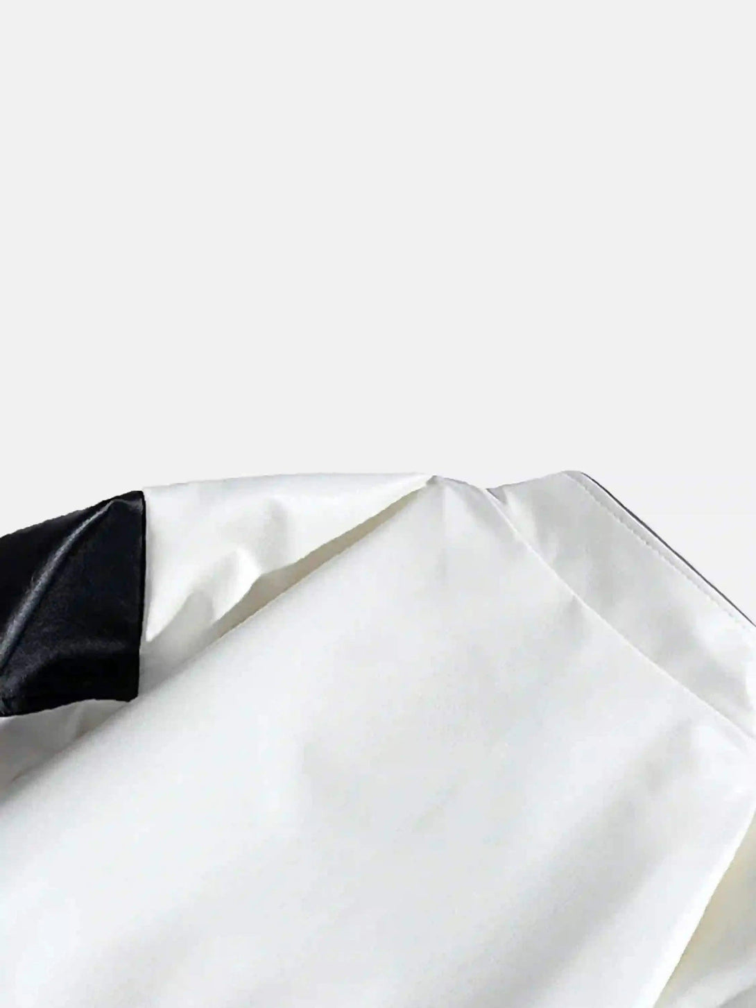 Intricate look at the sleeve detail of a white racing baseball jacket by TALISHKO.