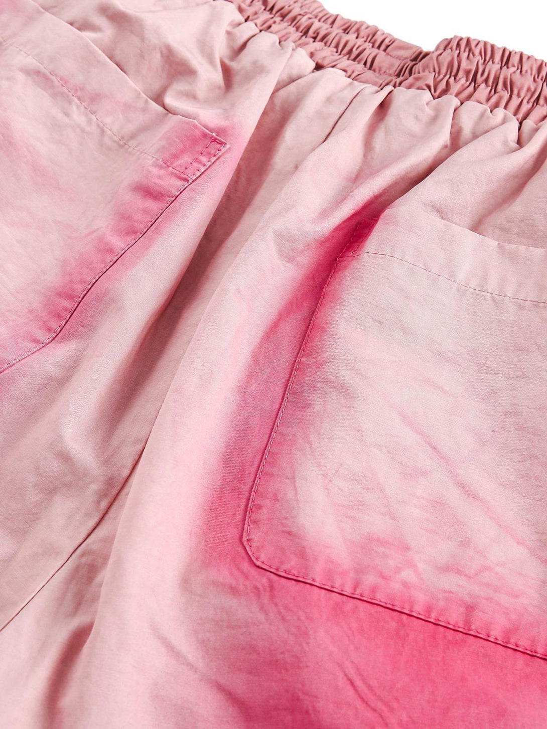 Close-up of pink spray paint casual shorts by TALISHKO, focusing on the elastic waist and pockets.