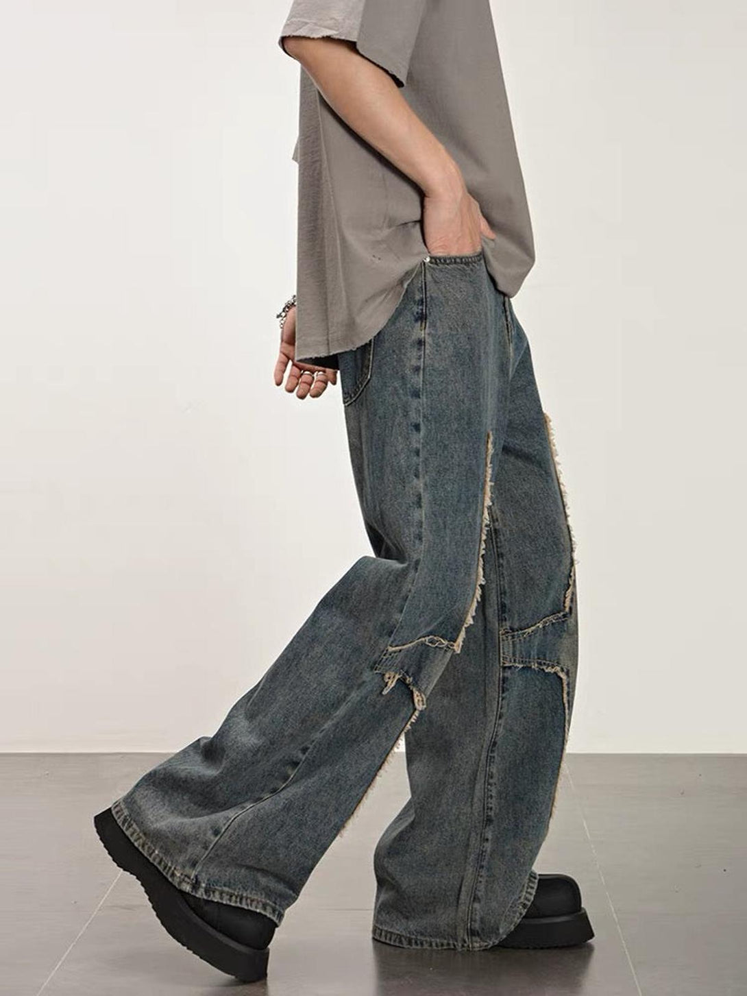 Model in TALISHKO washed jeans, featuring distressed wide-leg style and casual fit.