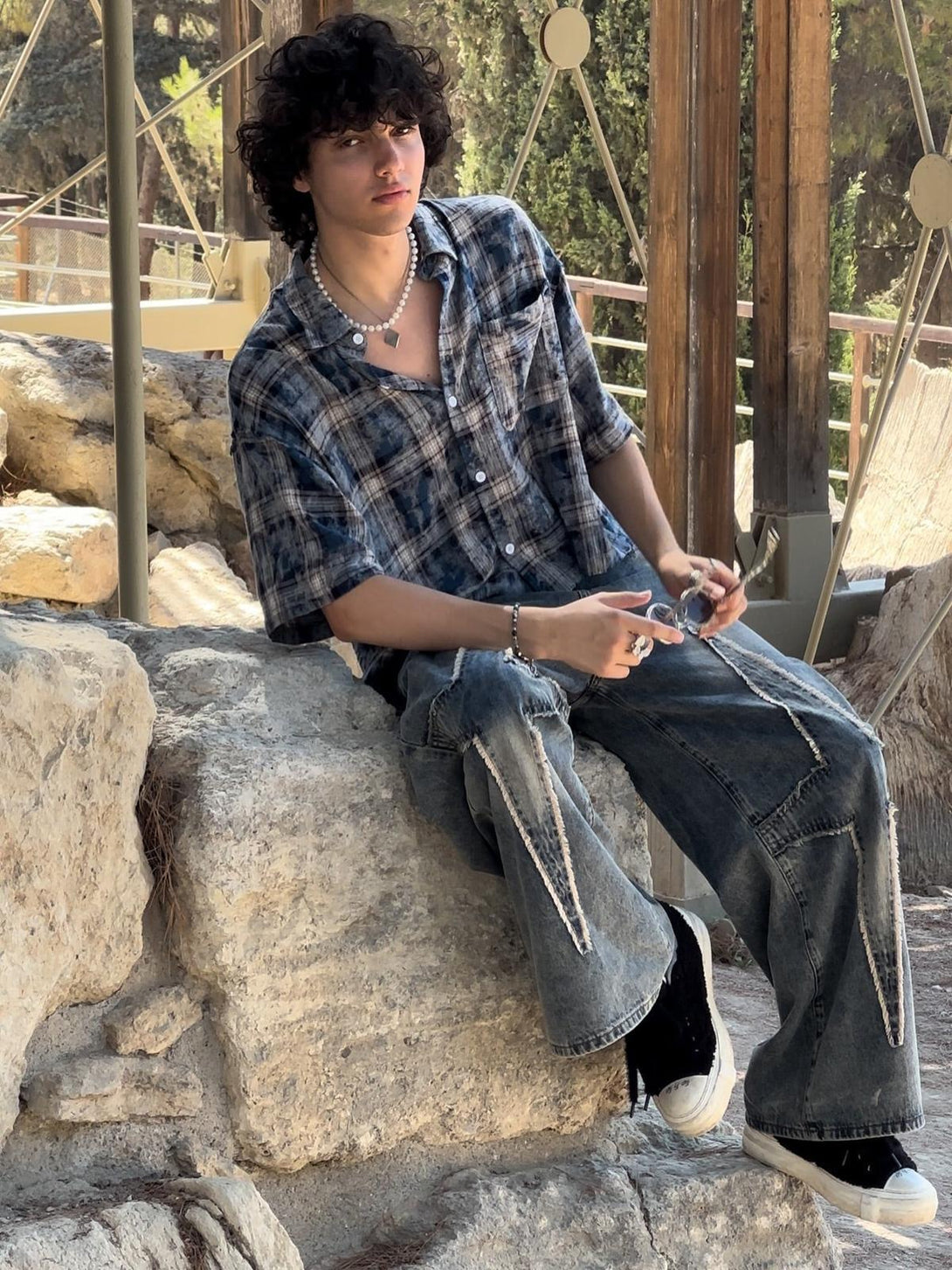 Model in TALISHKO washed jeans, featuring unique stitching and a relaxed, casual fit.