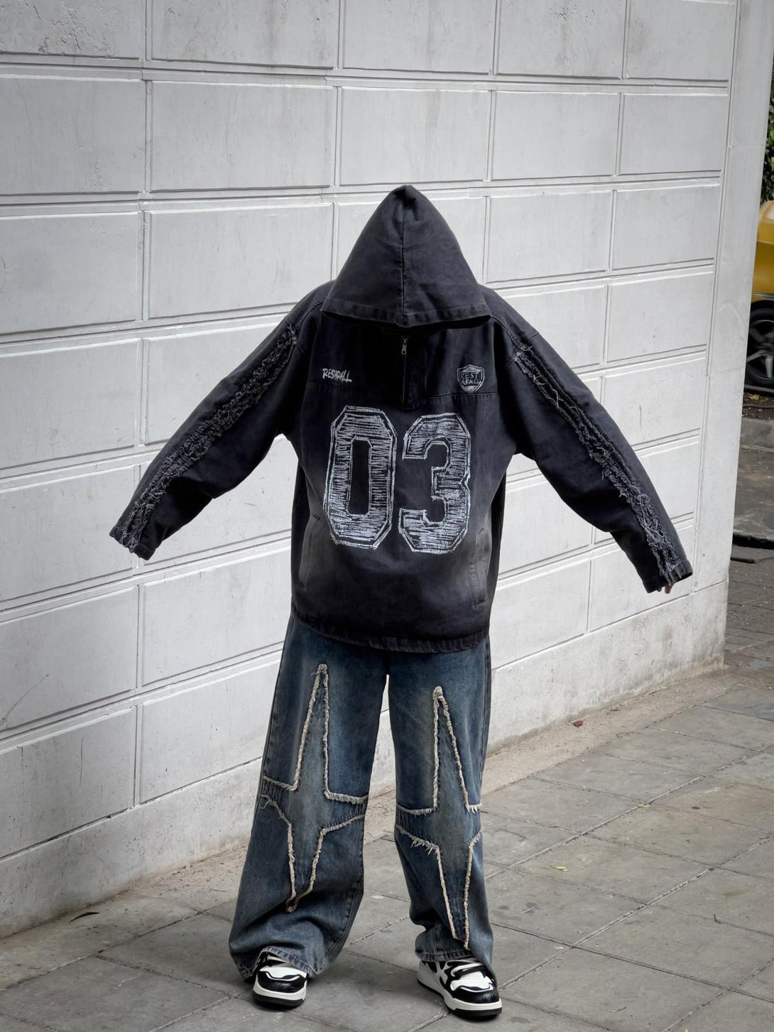 TALISHKO streetwear outfit featuring a hooded jacket and star-patterned wide-leg jeans.