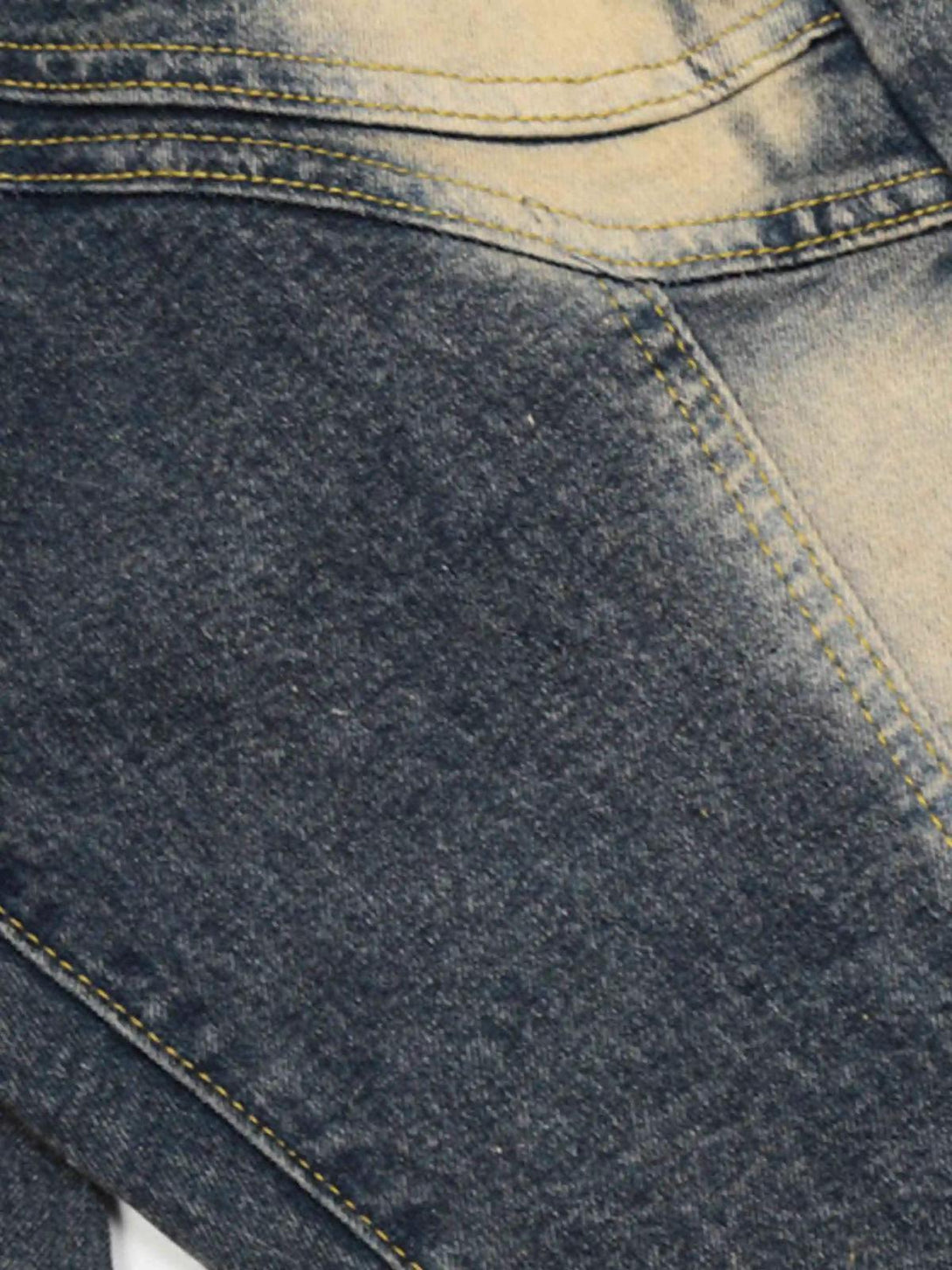 Intricate look at TALISHKO flared jeans, focusing on the bleached denim texture and stitching.