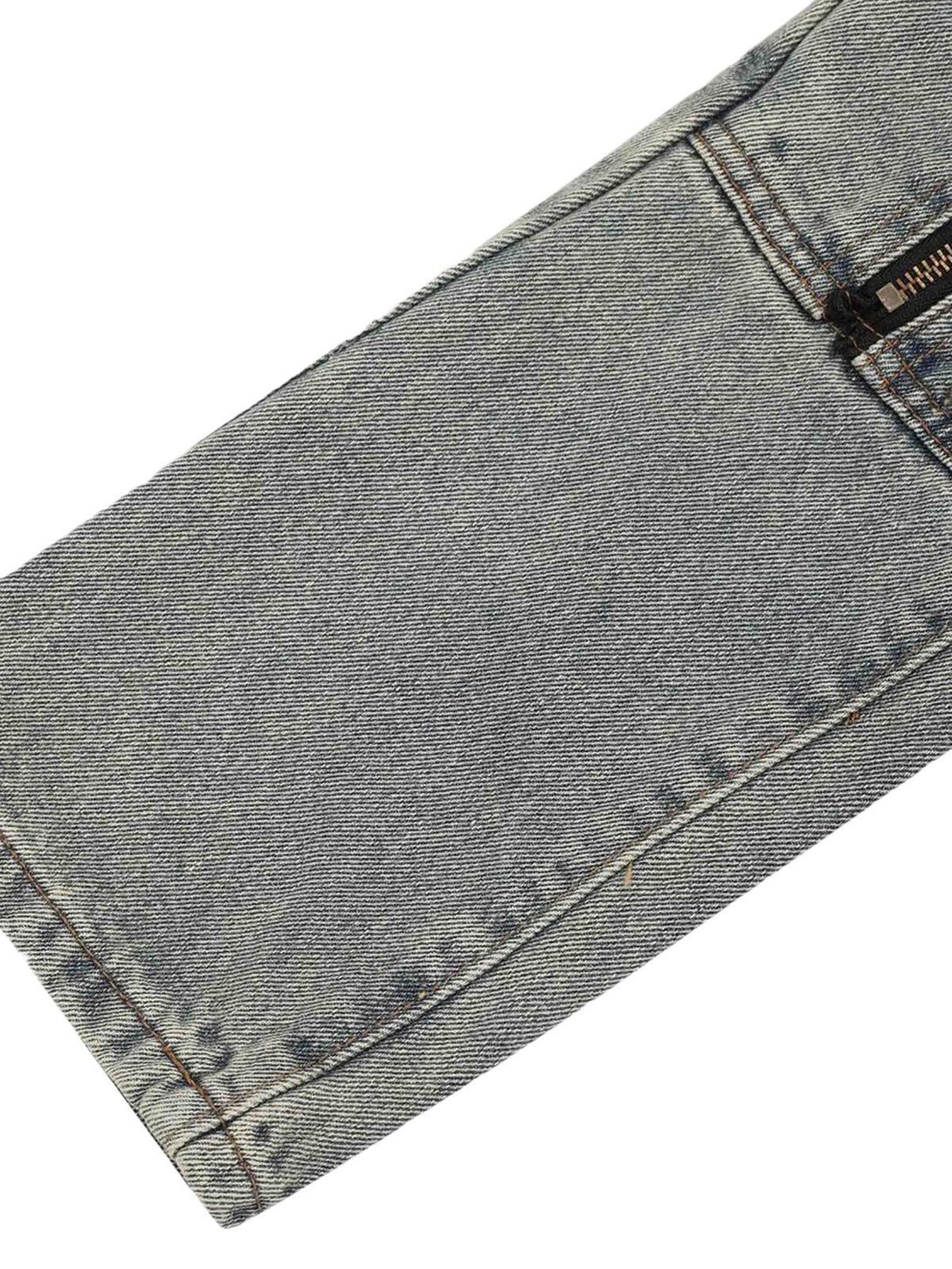 Detailed fabric and stitching of TALISHKO denim pants, highlighting the zipper and texture.