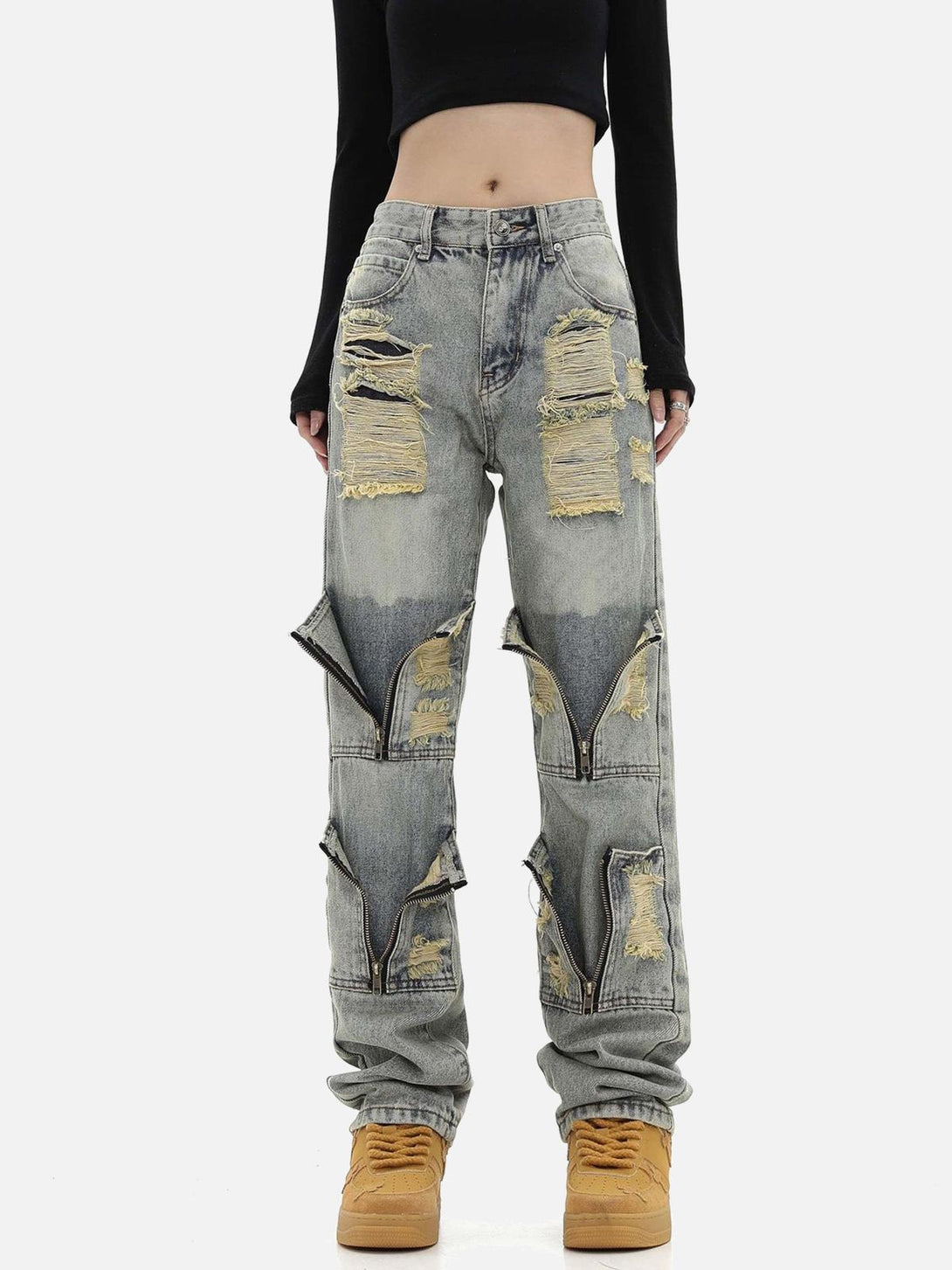 Model wearing TALISHKO distressed denim pants with unique zipper accents and torn details.