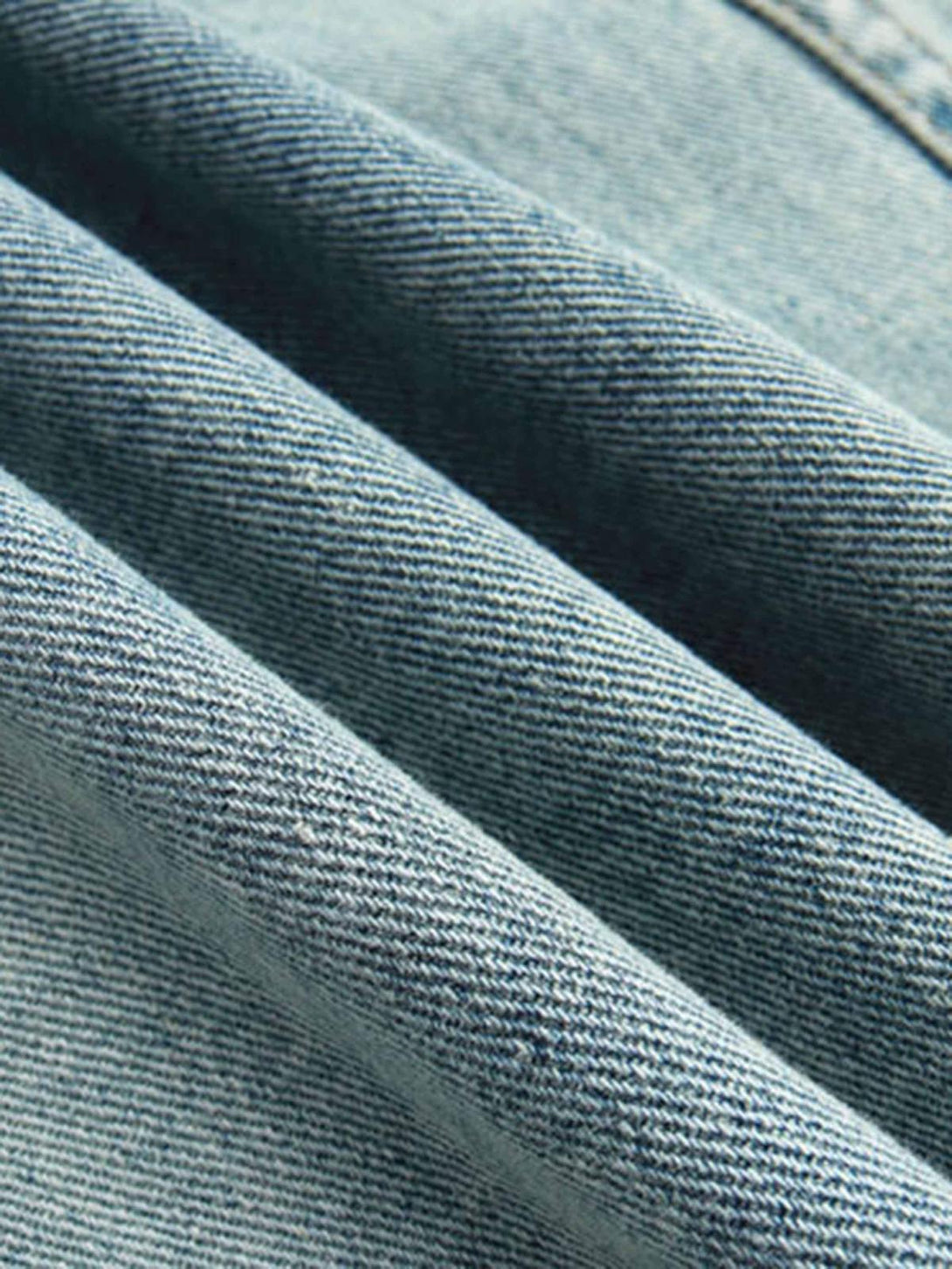 Texture and pattern showcased in TALISHKO's denim hoodie, highlighting its washed look.