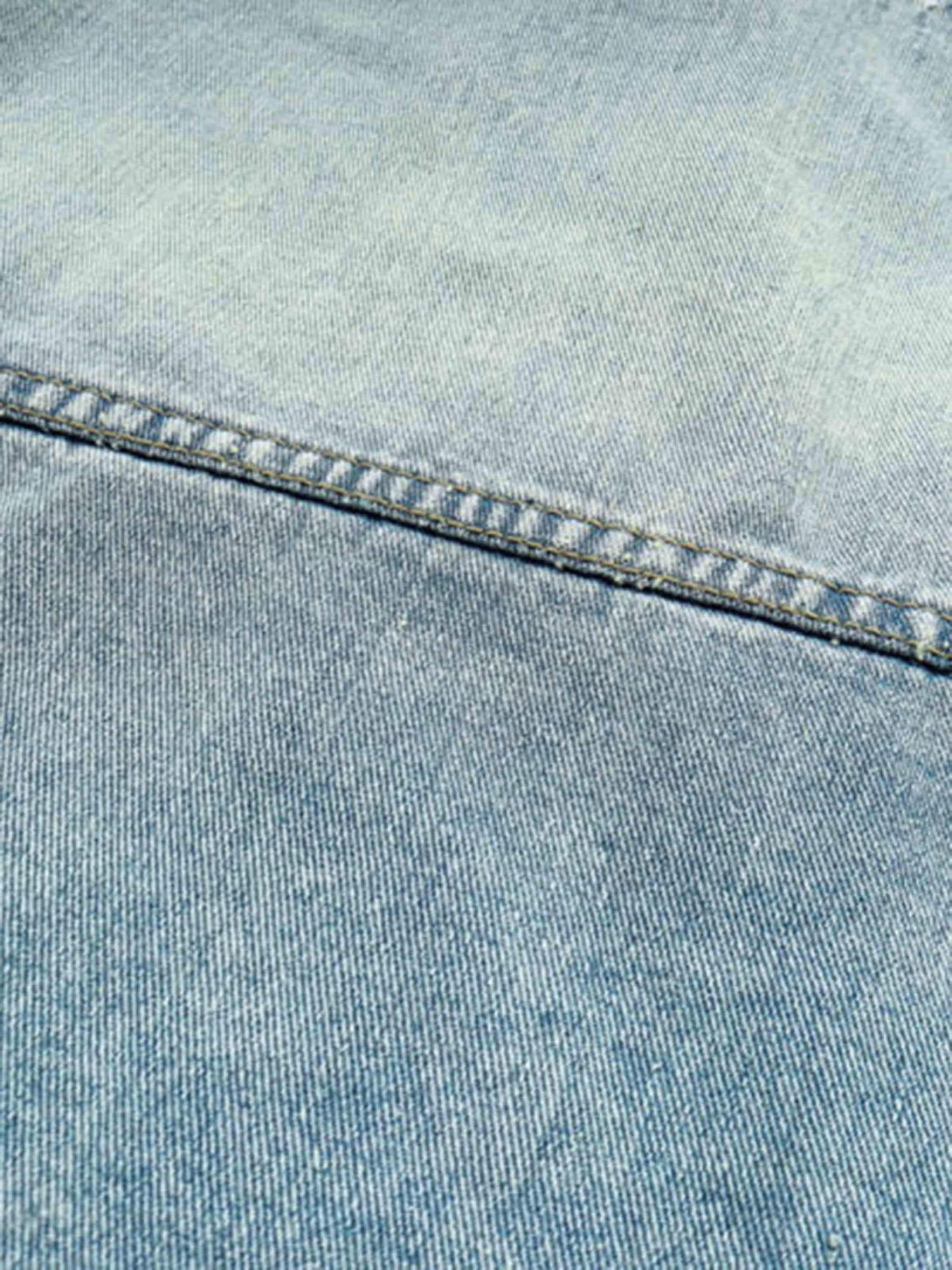 Zoomed-in texture of the TALISHKO denim hoodie, showcasing its washed and worn fabric.