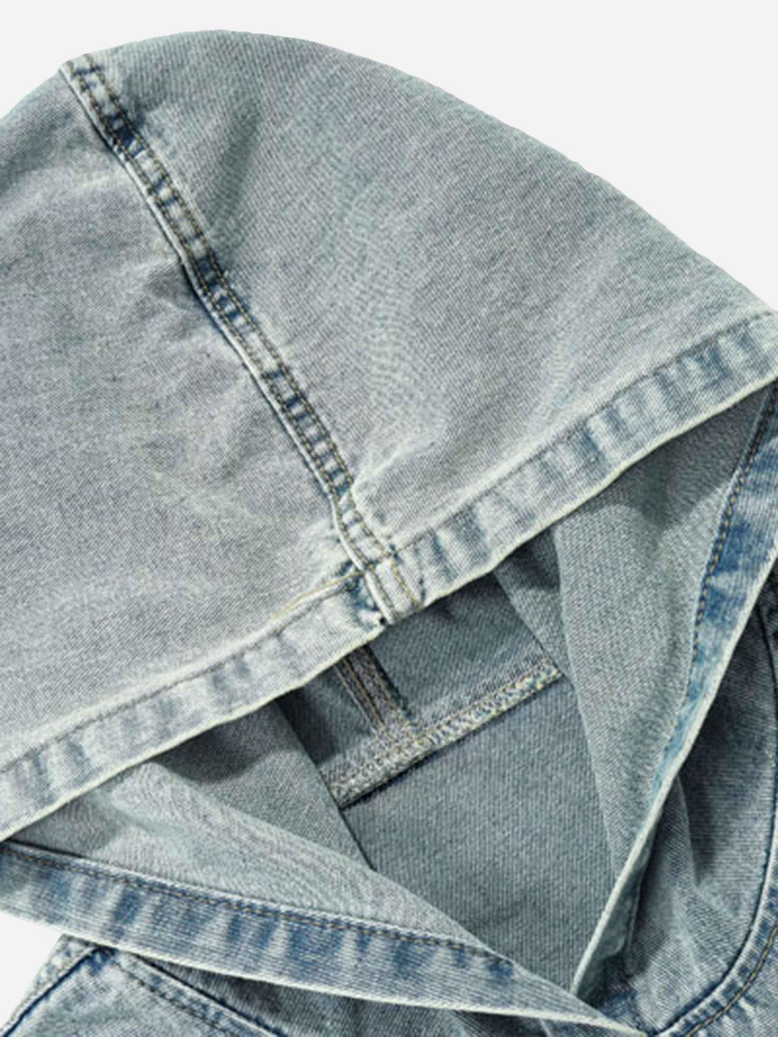 A detailed look at the washed denim hoodie by TALISHKO, highlighting its unique stitching.