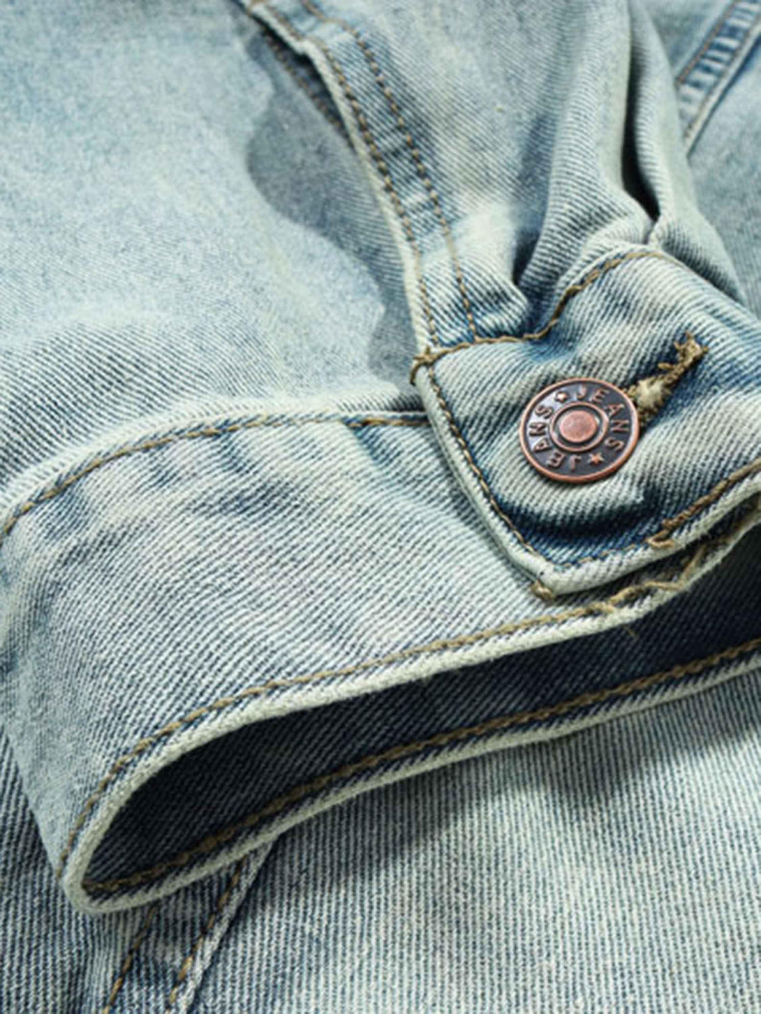 A close-up of TALISHKO's washed denim hoodie, highlighting the button and stitching details.