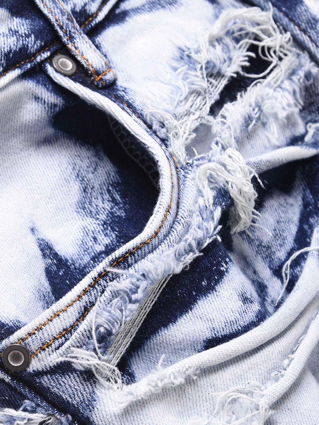 Intricate look at TALISHKO high street washed jeans, highlighting frayed details and texture.
