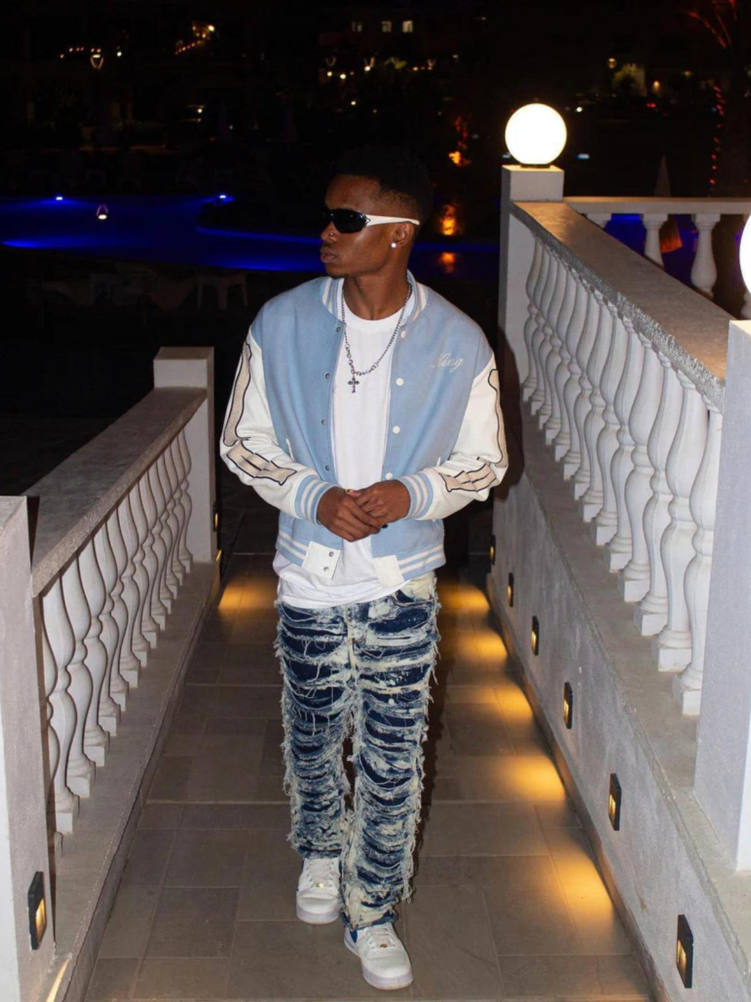 Model wearing TALISHKO slim fit jeans with a distressed design, paired with a stylish jacket.