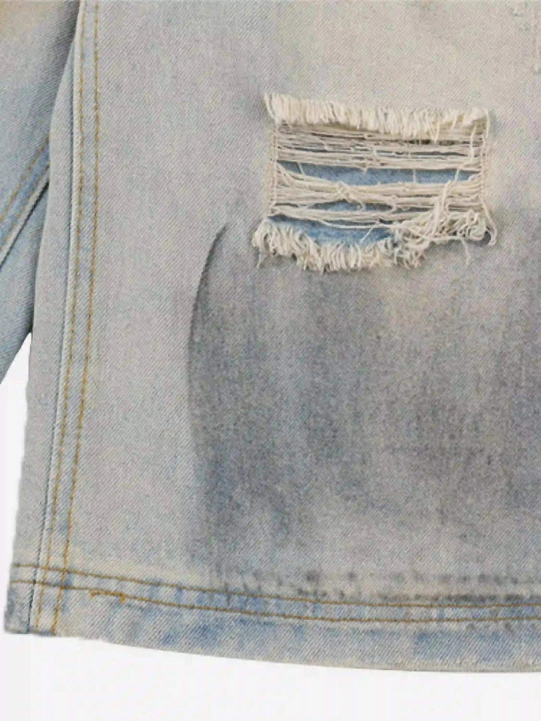 A close-up of TALISHKO denim shorts highlighting distressed details and unique texture.