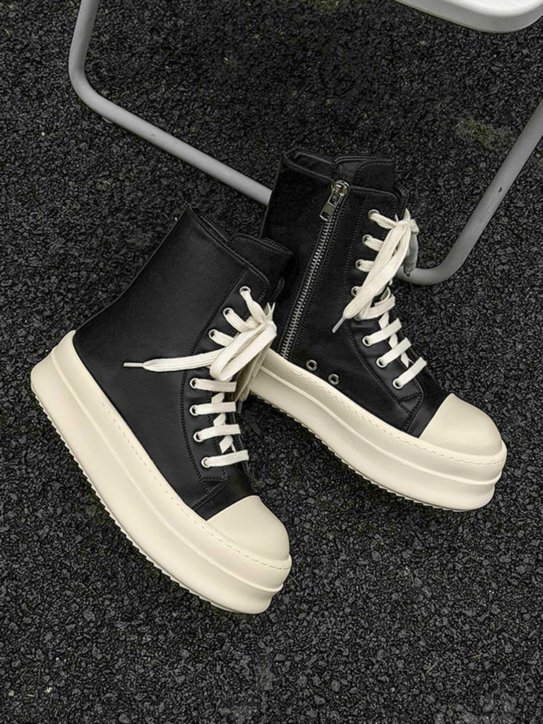 High-top platform sneakers by TALISHKO, featuring a side zipper and white laces on asphalt.