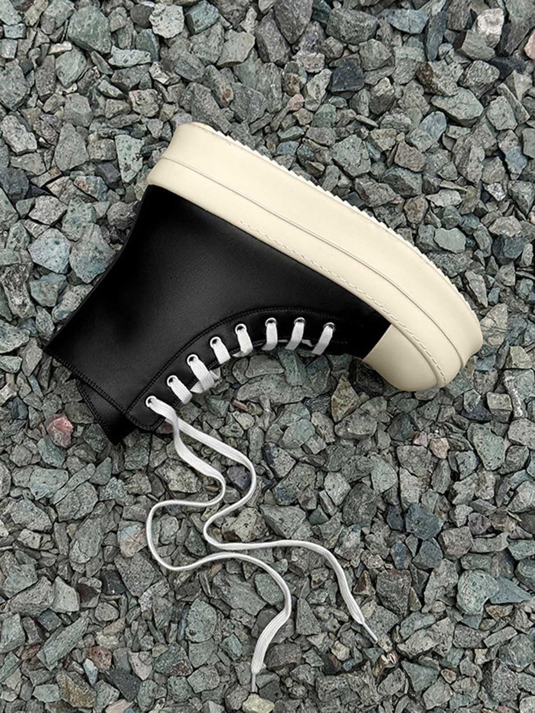 High-top platform sneakers by TALISHKO, highlighted against a textured stone background.