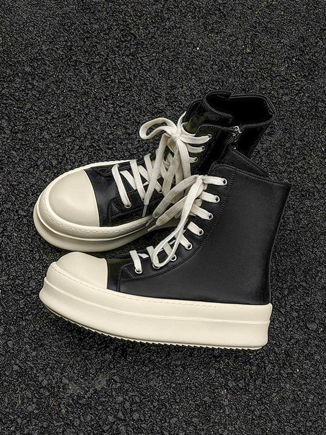 High-top platform sneakers with side zippers by TALISHKO, featuring white laces on asphalt.