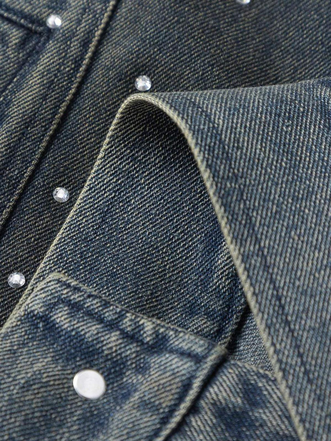 A detailed view of TALISHKO's washed denim jacket, emphasizing the beaded embellishments.