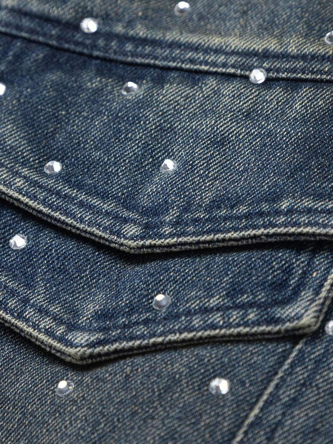 Zoomed-in texture of TALISHKO's denim jacket, highlighting sparkling bead embellishments.
