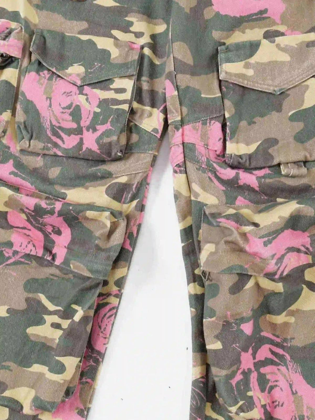 Zoomed-in texture of TALISHKO cargo pants, highlighting pink-accented camouflage pattern.