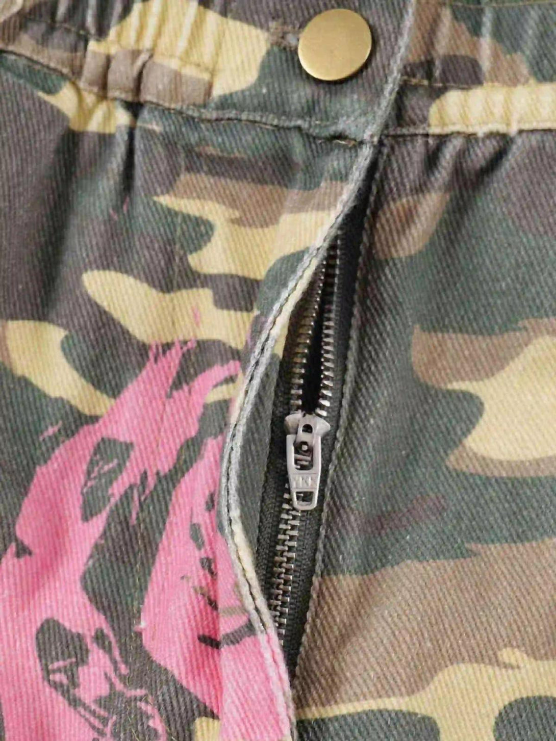Focusing on TALISHKO's cargo pants zipper, featuring pink-accented camouflage design.