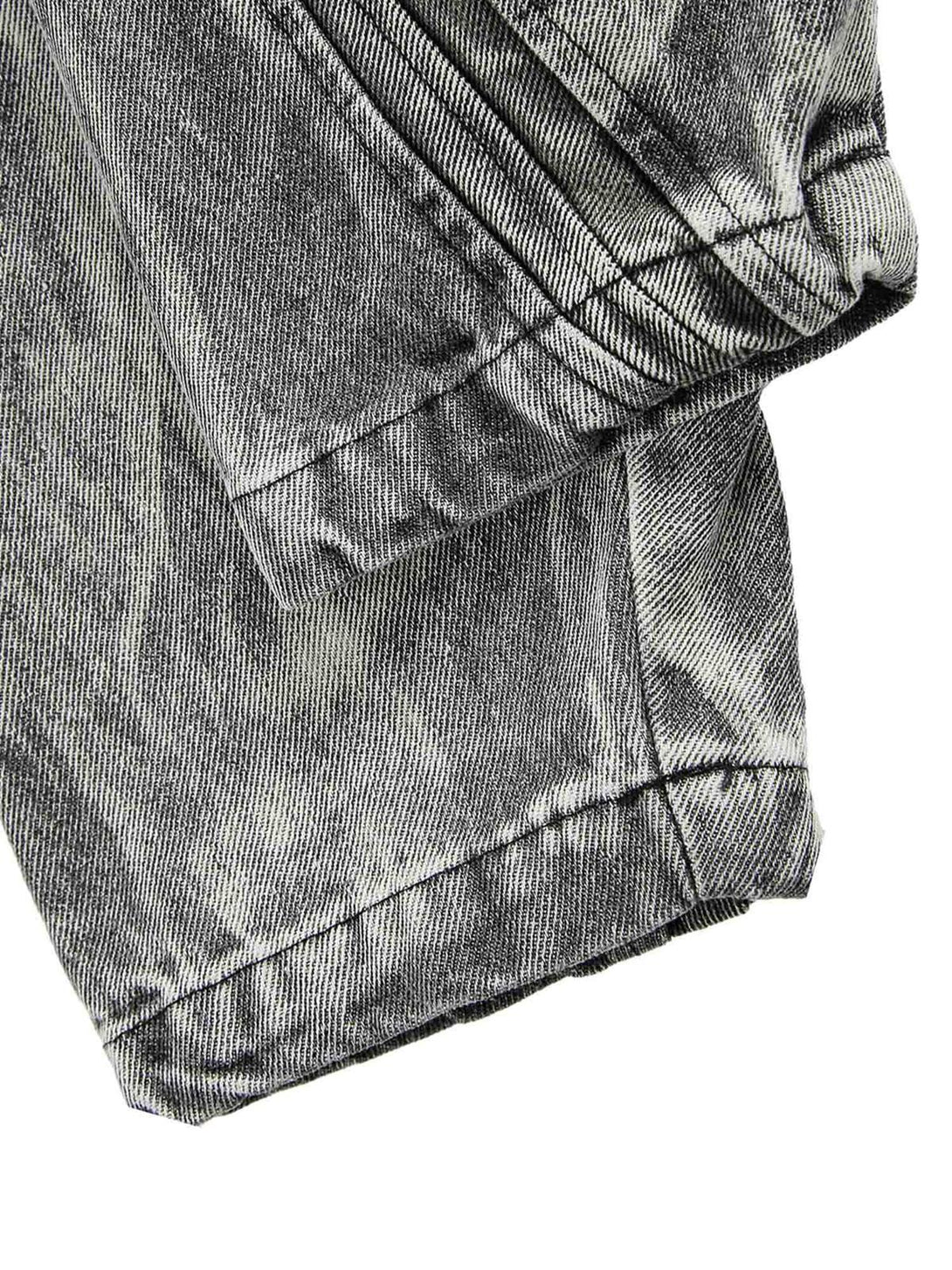 Intricate look at the hem stitching on TALISHKO's distressed denim jacket, showcasing texture.