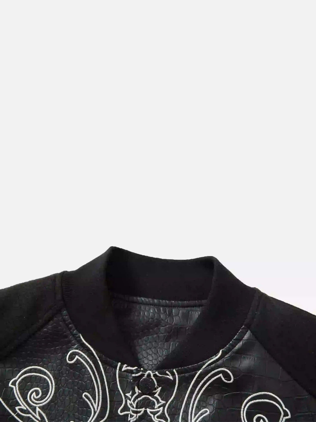 Intricate look at TALISHKO baseball jacket's neckline, showcasing gothic embroidery detail.