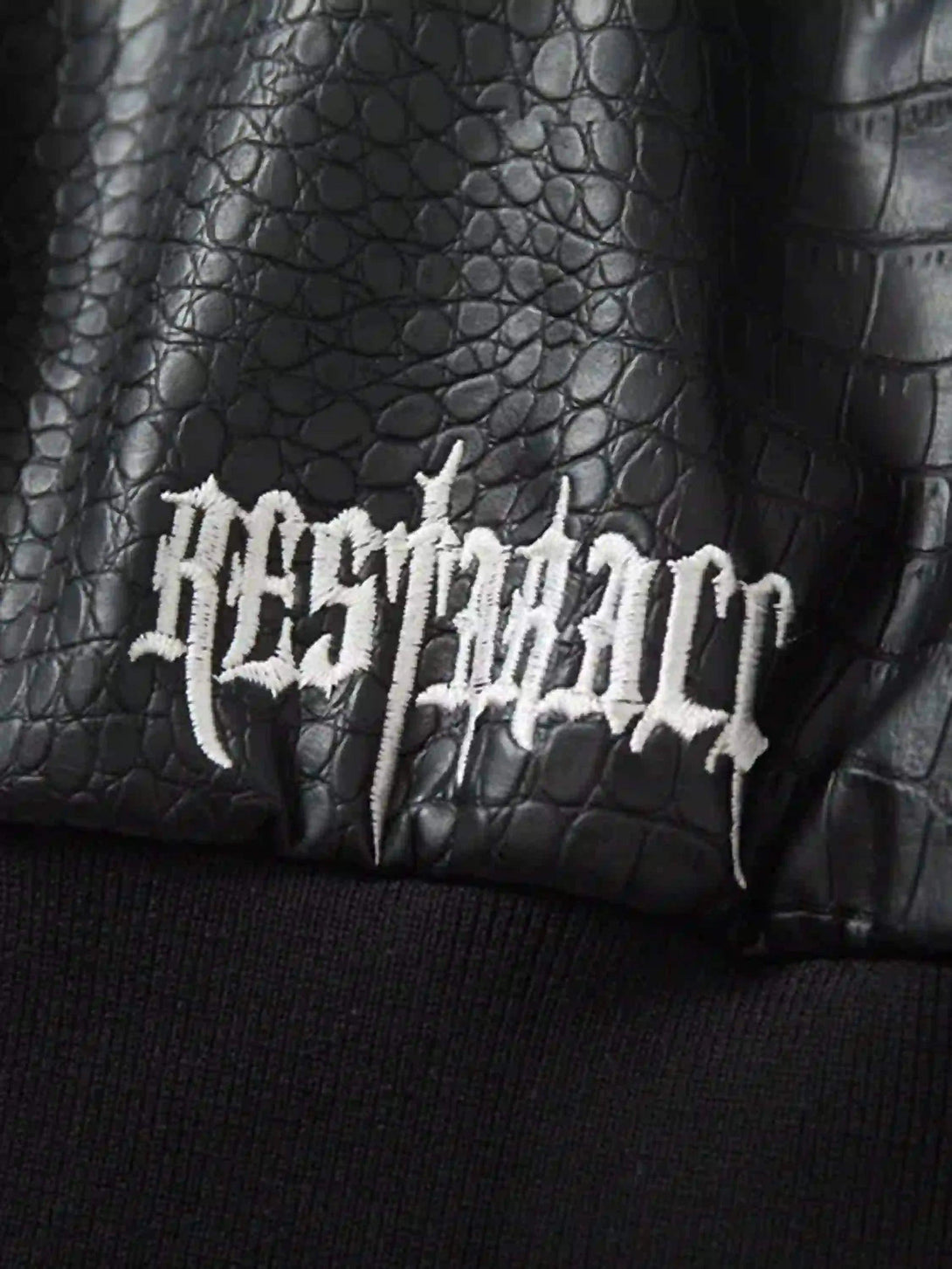 Focusing on the TALISHKO jacket's embossed texture and gothic embroidered detail.