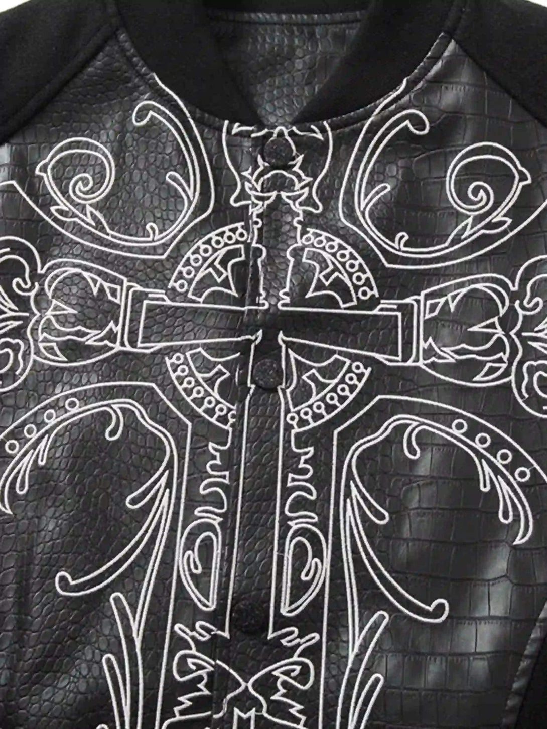 Intricate design detail from TALISHKO baseball jacket with gothic embroidery on faux leather.