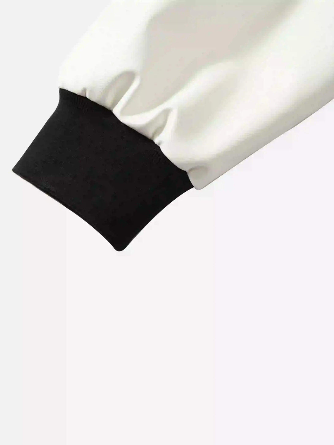 Detailed view of TALISHKO baseball jacket's cuff, highlighting its black and white contrast design.