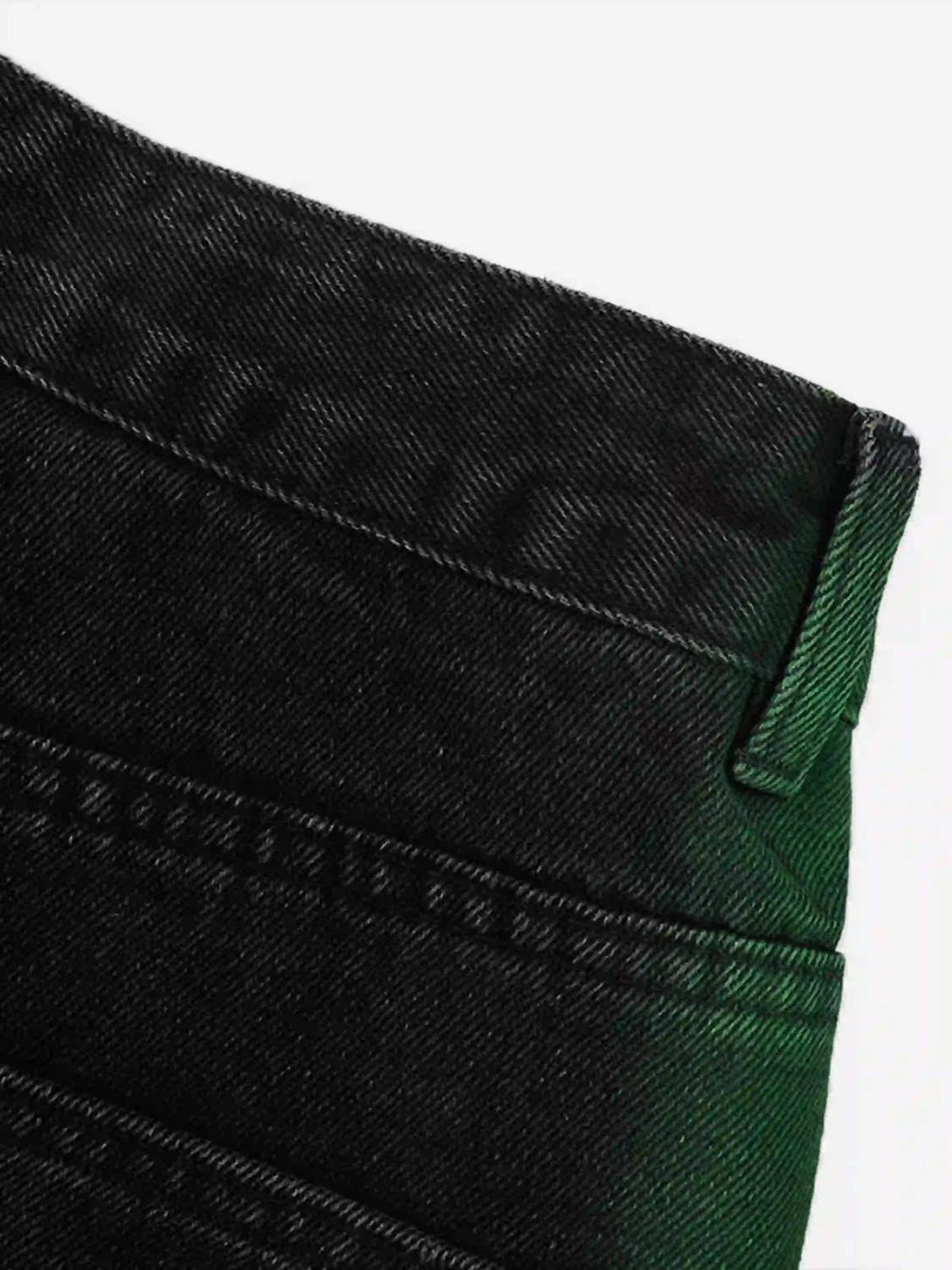 Intricate look at TALISHKO's green hand-painted jeans, highlighting unique stitching details.