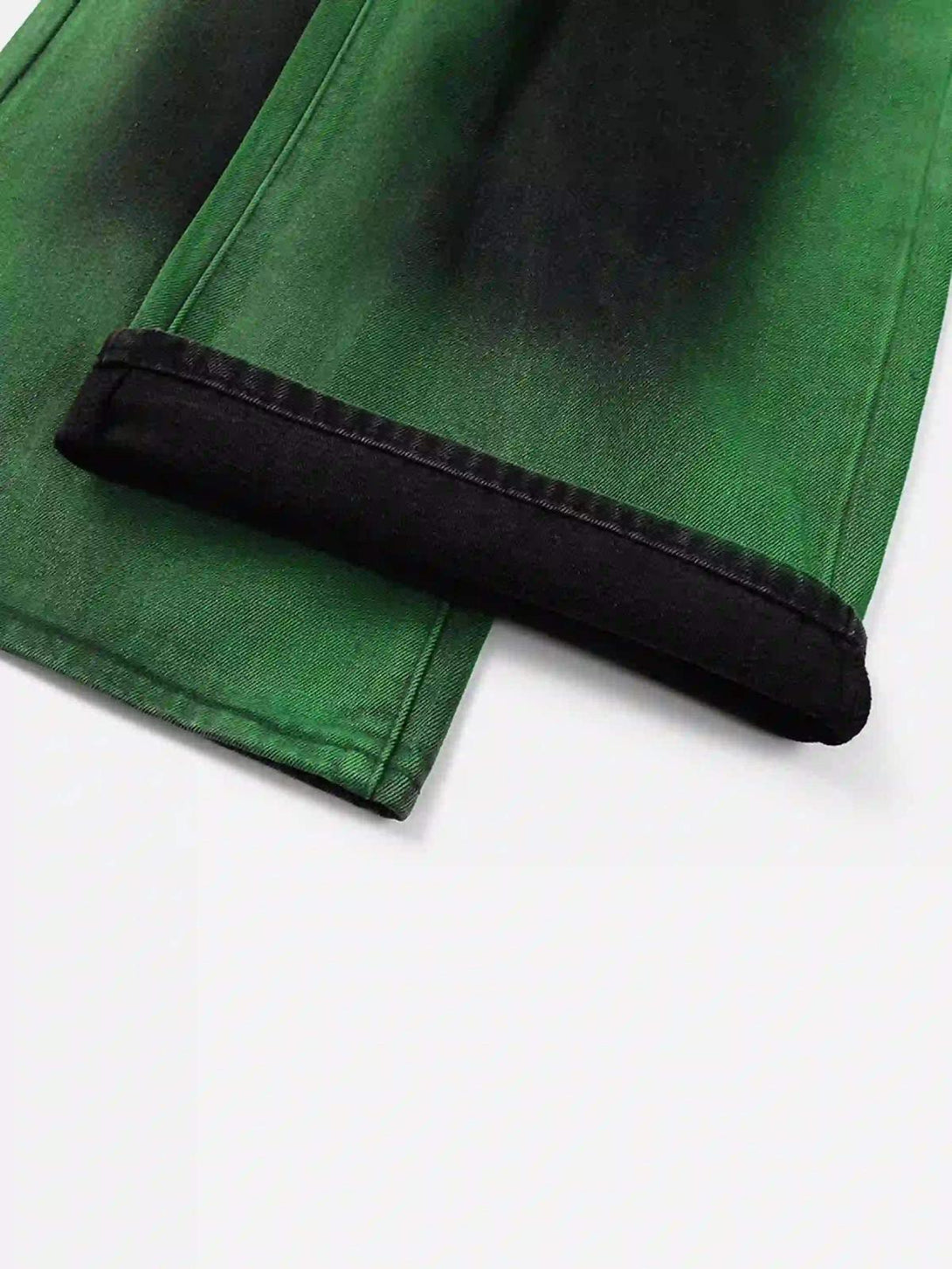 A tight crop highlighting TALISHKO's hip-hop jeans, showcasing green hand-painted hem detail.