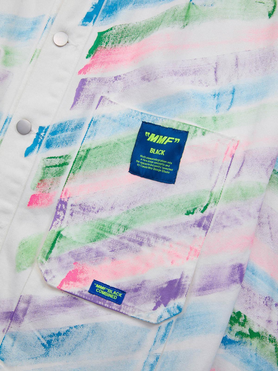 A detailed view of TALISHKO's graffiti denim jacket, featuring vibrant pastel brushstrokes and pocket detail.