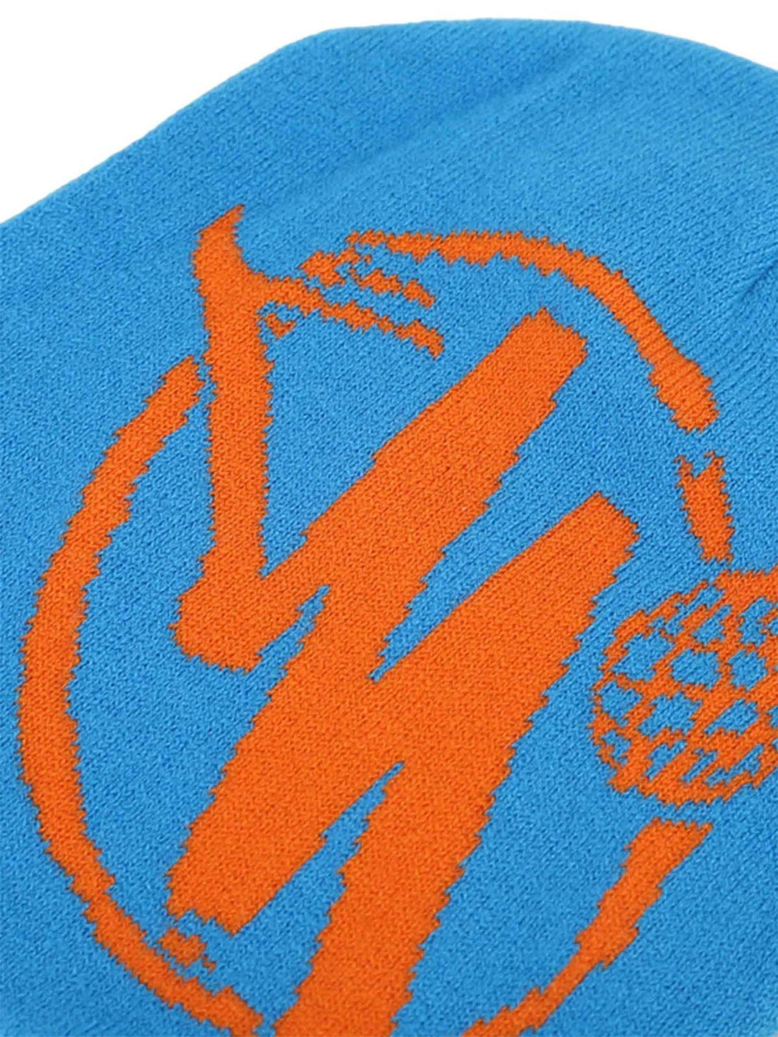 Intricate orange graphic on a blue knit hat by TALISHKO, showcasing bold hip hop style.