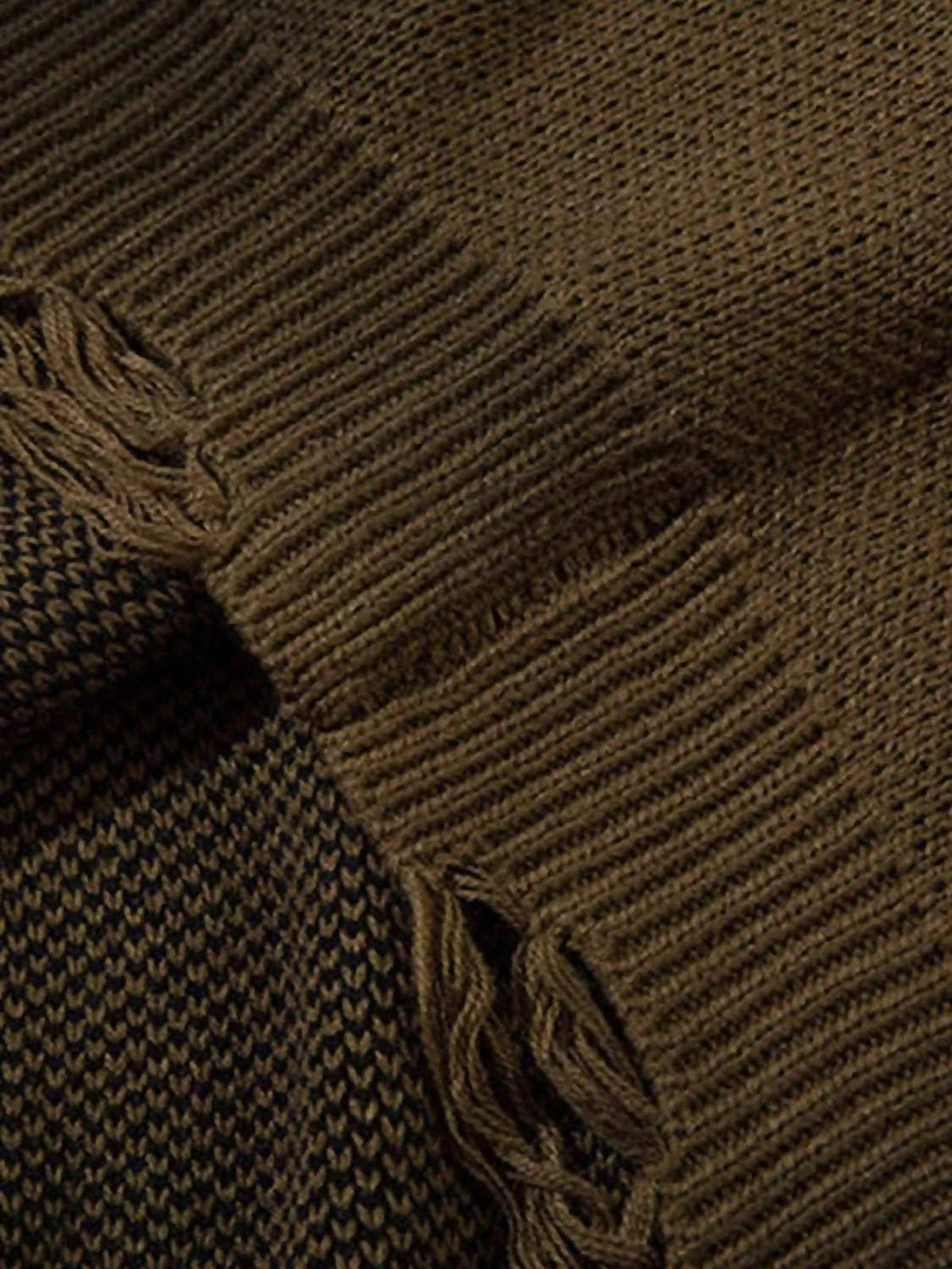 A detailed view of TALISHKO sweater's distressed edge, highlighting the intricate knit texture.