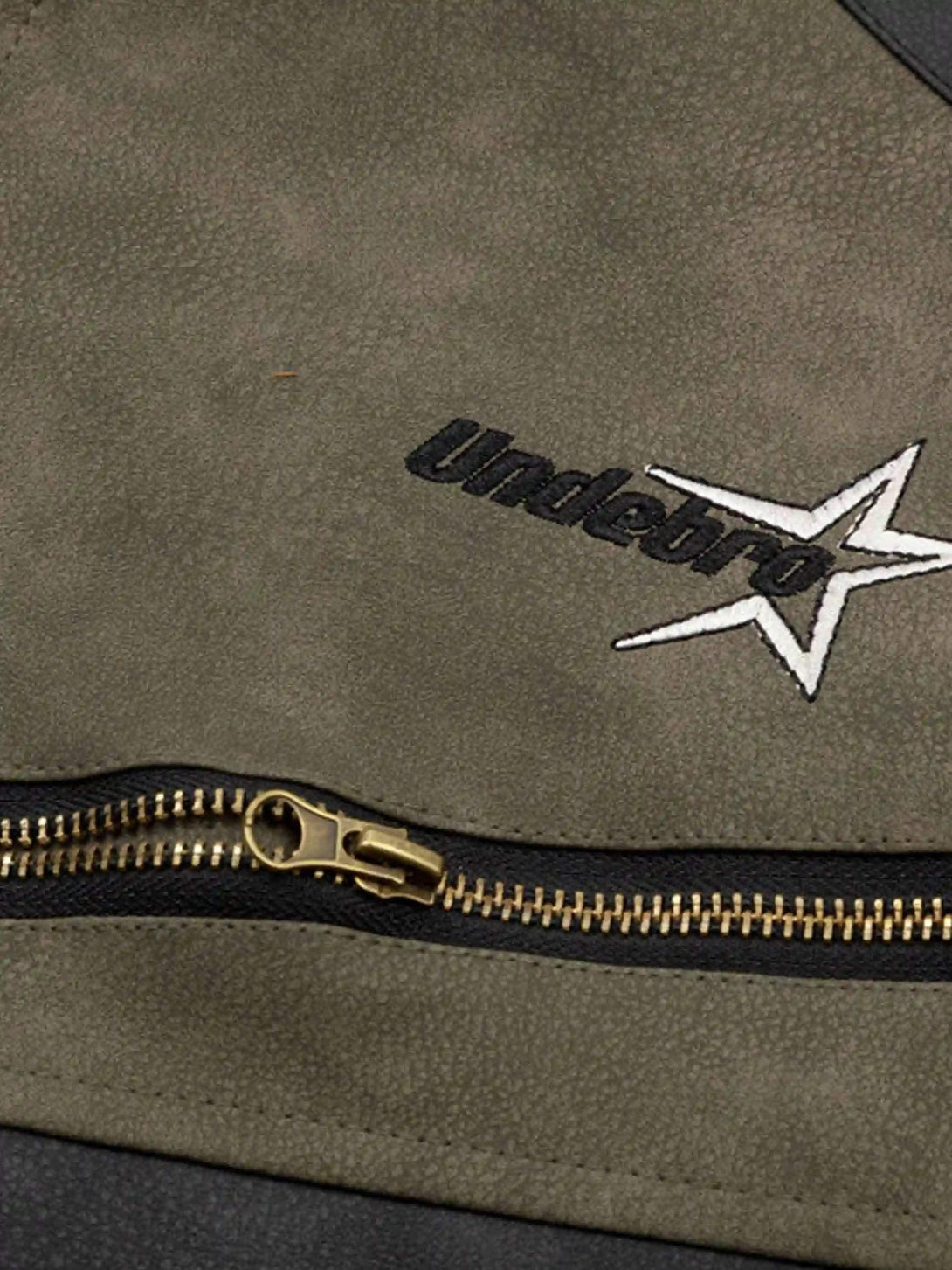 Focusing on the zipper and logo detail of a hip-hop motorcycle jacket by TALISHKO.