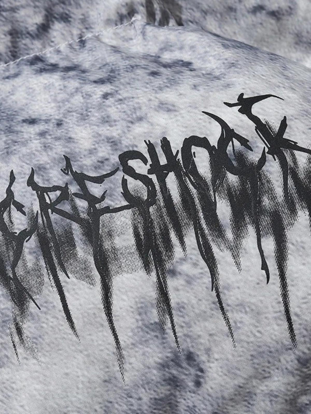 A tight crop highlighting the artistic lettering on a TALISHKO hip hop oversized padded jacket.