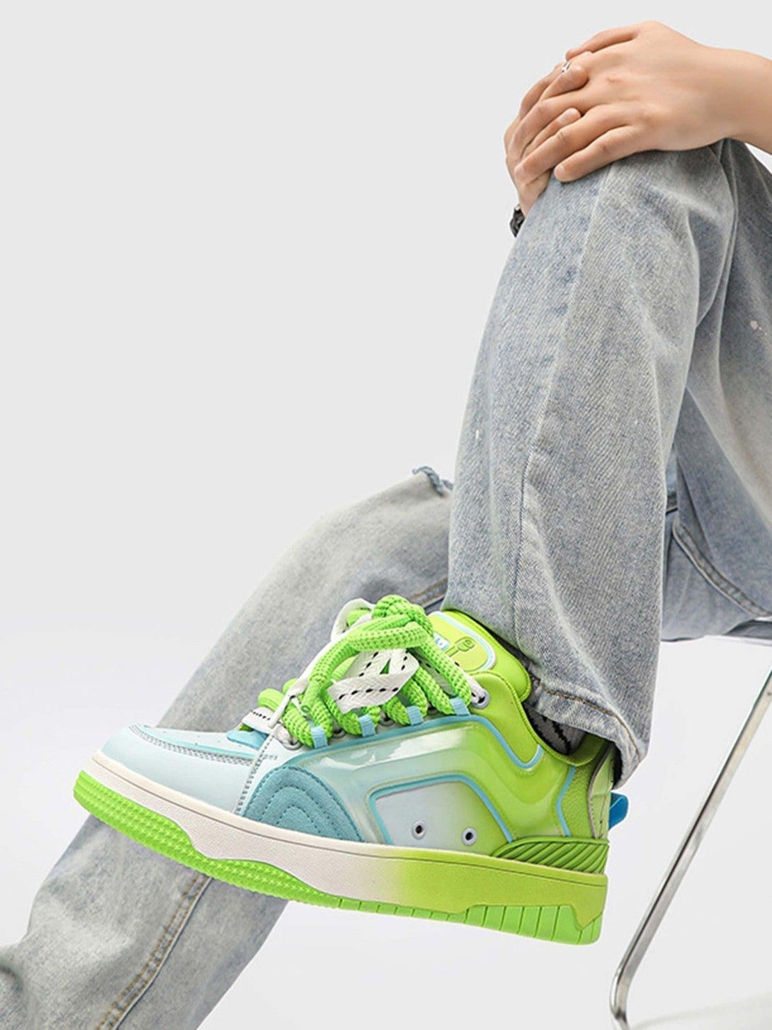 TALISHKO skateboard shoes in blue and green, paired with jeans for a trendy street look.