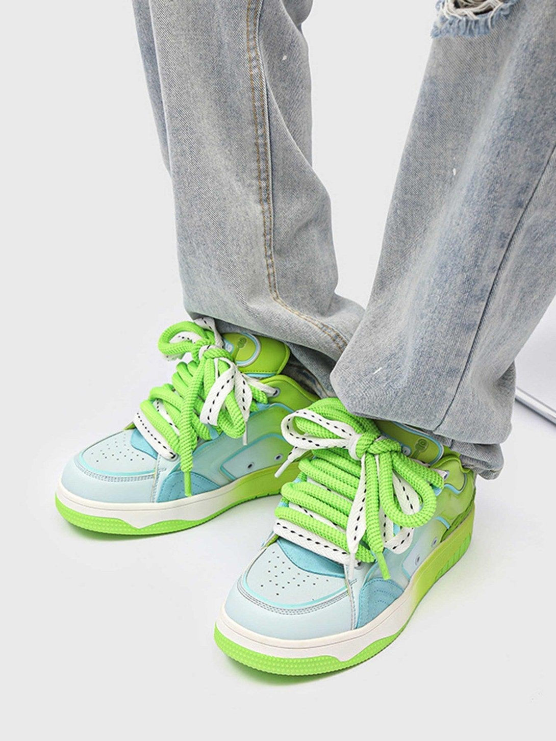 Hip-hop style skateboard shoes by TALISHKO in vibrant green and blue, worn with casual jeans.