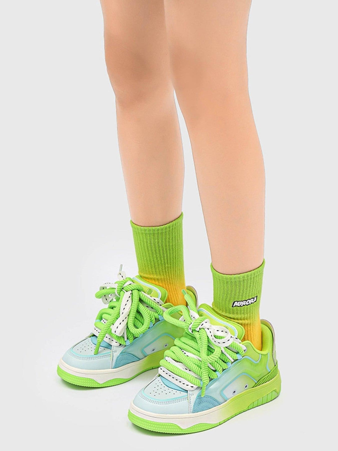 TALISHKO skateboard shoes in green and blue, highlighted with bold laces and colorful socks.