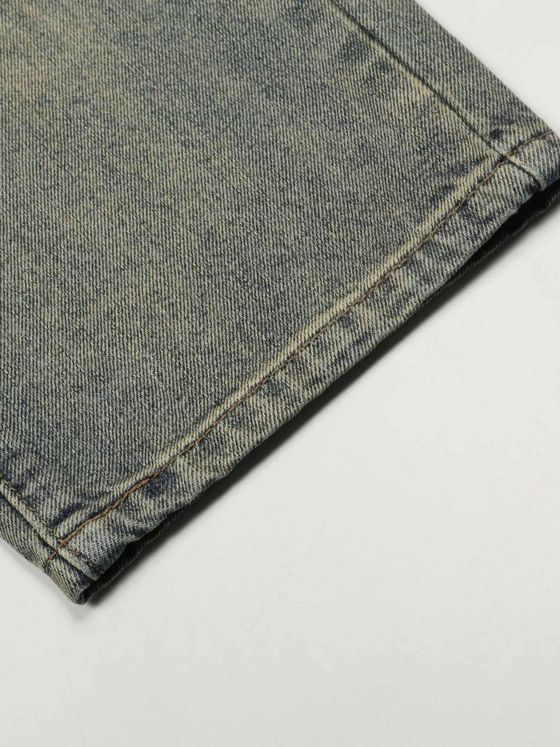 Intricate look at TALISHKO's retro denim jeans hem, highlighting unique stitching details.