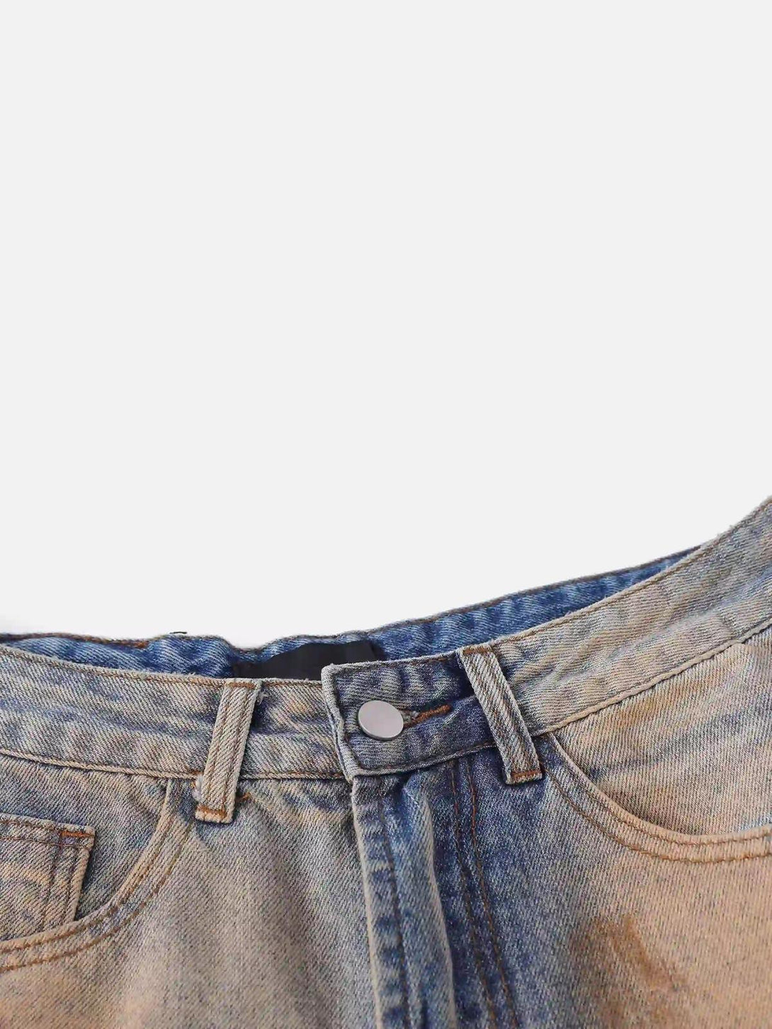 A close-up of TALISHKO hip-hop mud-dyed jeans, highlighting the textured waistband and button.