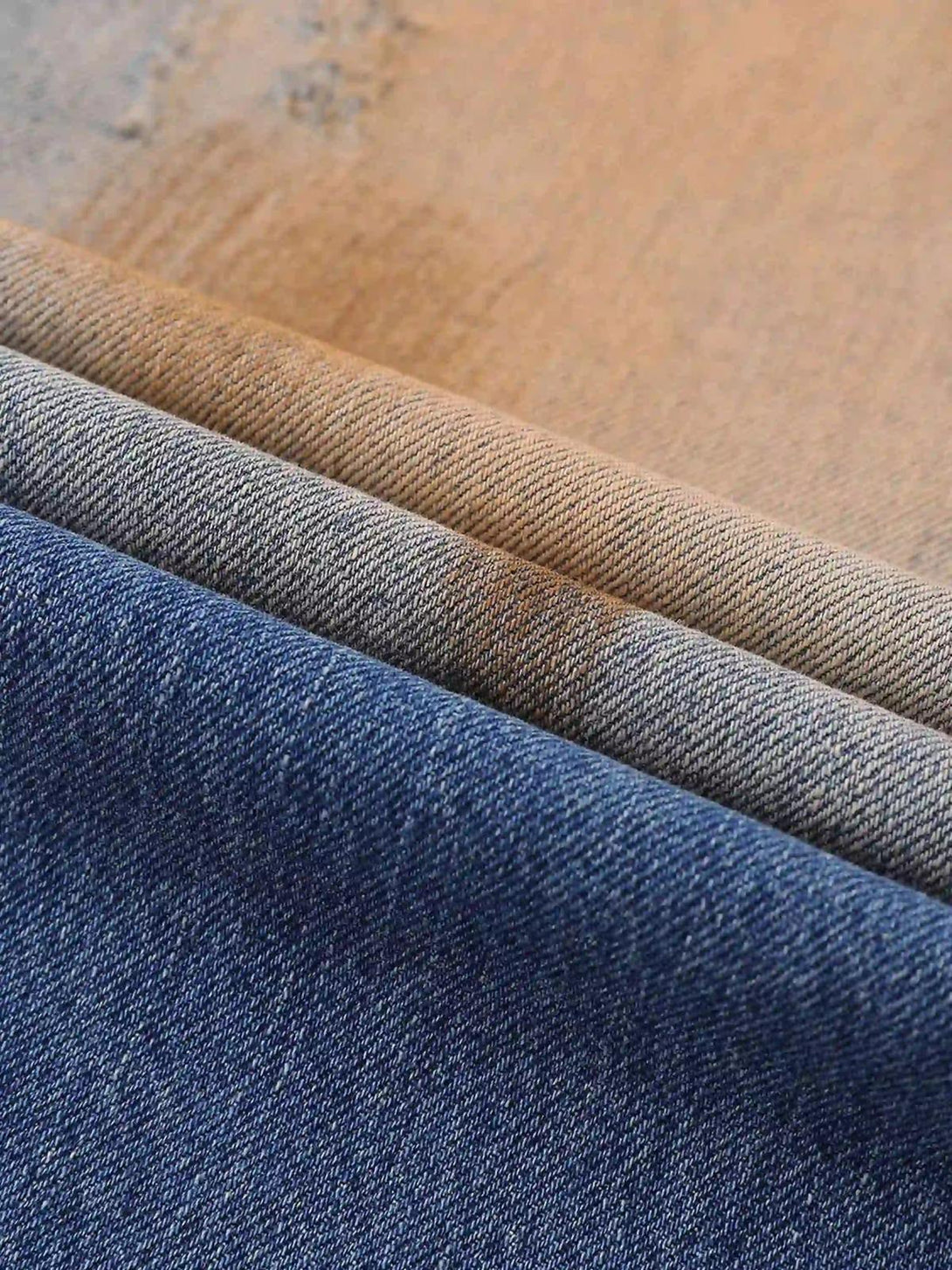 Texture and pattern showcased in TALISHKO hip-hop ripped jeans, emphasizing mud-dyed fabric.